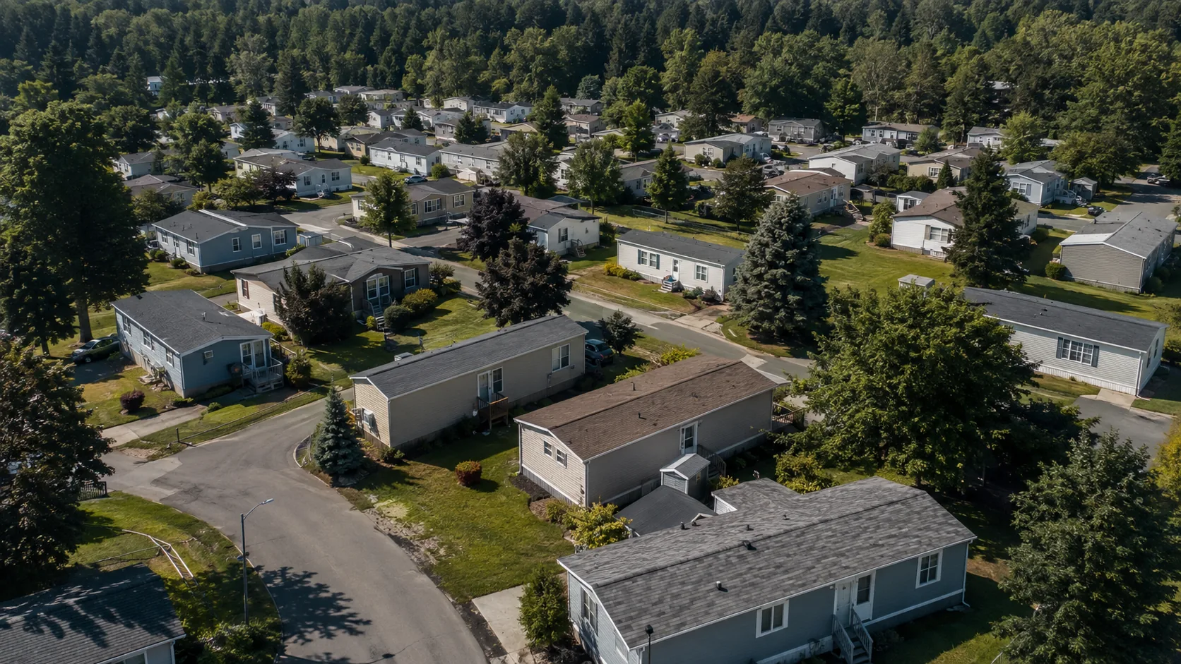 Aerial view of a well-maintained manufactured-housing community with homes, roads and shared infrastructure