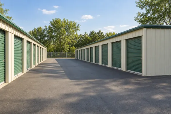 An orderly self-storage property with green roll-up doors